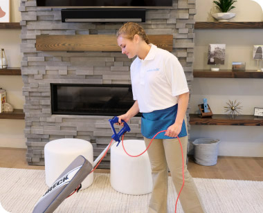 cleaner vacuuming a living room